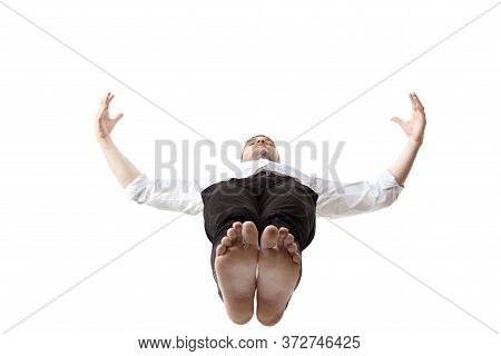Mid-air Beauty Cought In Moment. Full Length Shot Of Young Man Hovering In Air And Keeping Eyes Clos