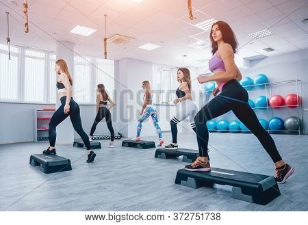Young Fitness Women Using Step Platform At The Gym.  Training.