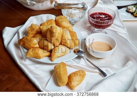 Nationally Kazakh Dish Baursaks Lie On A White Plate With A Cup Of Tea With Milk