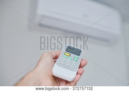 Air Condition Remote Control. Hand With Room Conditioner Remote Control. Air Temperature Switch For 
