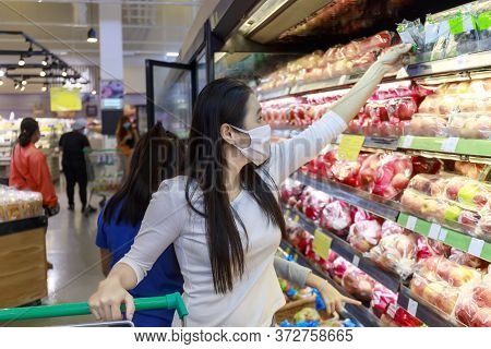 Asian Woman Wear Face Mask Push Shopping Cart In Suppermarket Departmentstore. Girl, Looking Grocery