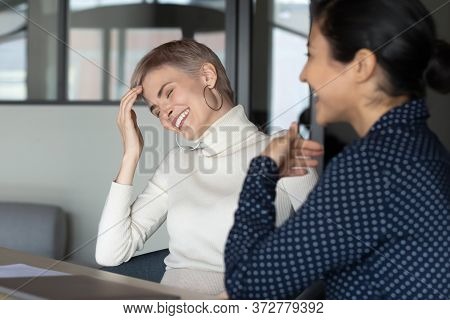 Diverse Colleagues Laughing Over Joke During Workday Break