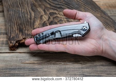 A Knife Placed In The Palm Of Your Hand. The Knife Is Folded.