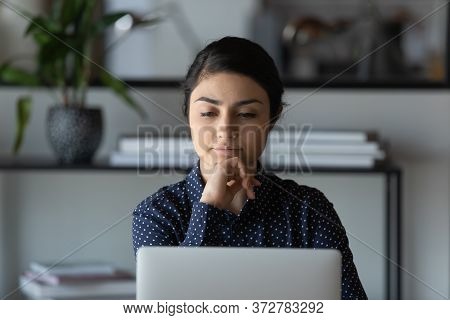 Indian Employee Looking At Laptop Screen Thinking Over Problem Solution