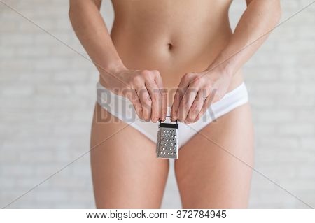 Unrecognizable Woman In White Panties Holds In Hands A Mini Grater. Metaphor Of The Bristles After D