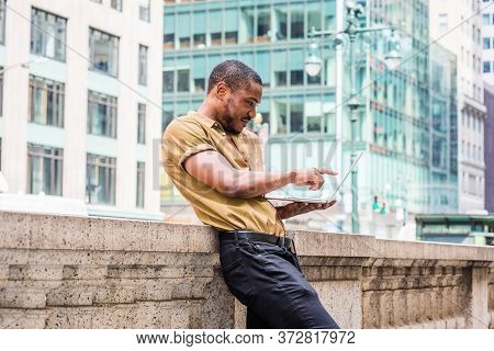 Young African American Man Working In New York City, Wearing Green Short Sleeve Shirt, Standing Agai