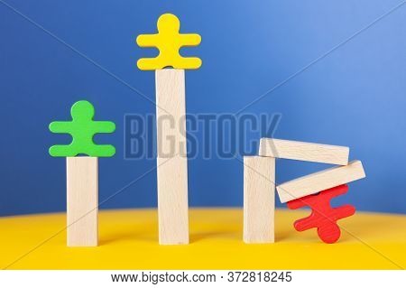 Multi-colored Figures Stand On Top Of Wooden Posts, One Figure Fell