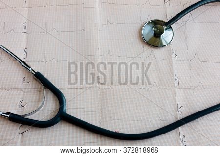 Medical Statoscope And Tablets Of Different Colors In Blisters On A Table With A Cardiologist Lies O