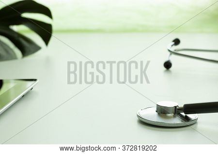 Close-up Of A Statoscope On A White Table And Free Space For Text, Light Green Background, Monstera 