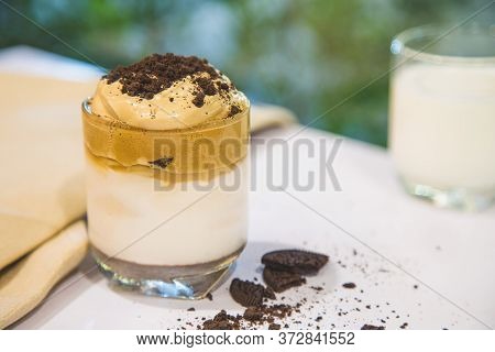 Homemade Dalgona Whipped Coffee With Cookies Crump In A Cup On A White Table With A Cup Of Milk Blur