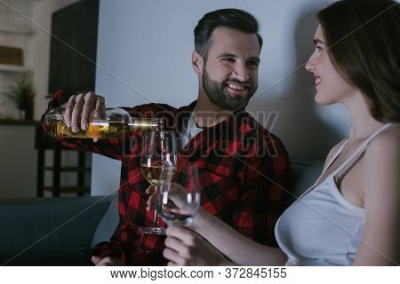 Girl Holding Glasses While Cheerful Man Pouring Wine