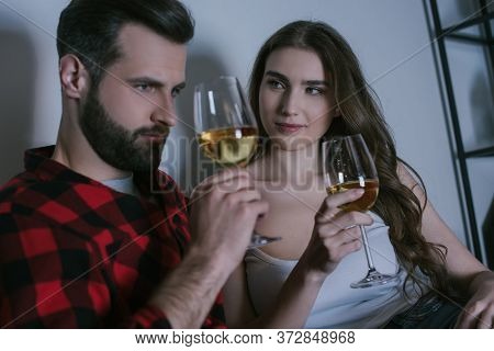 Girl Looking At Dreamy Boyfriend While Sitting Together With Glasses Of White Wine