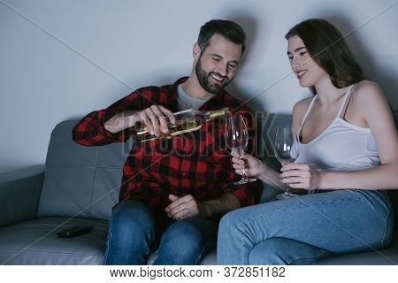 Man Pouring White Wine Into Glass Near Happy Girlfriend
