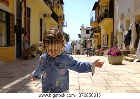A Little Girl Runs Happily In The Picturesque Italian Village. San Felice Circeo, Lazio, Italy