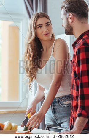 Attractive Young Girl Looking At Boyfriend While Cutting Fresh