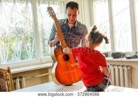 Closeup Mans Hand Changing Strings On His Old Acoustic Guitar.
