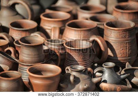 Traditional Ceramic Jugs On Decorative Towel. Showcase Of Handmade Ceramic Pottery In A Roadside Mar