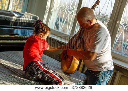 Closeup Mans Hand Changing Strings On His Old Acoustic Guitar.