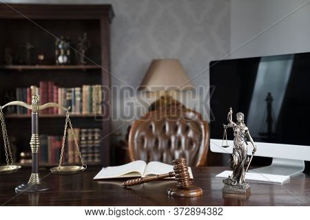 Law Theme. Judge Chamber. Gavel And Themis Statue On Brown Shining Desk. Collection Of Legal Books I