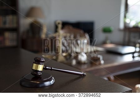 Law Theme. Judge Chamber. Gavel And Themis Statue On Brown Shining Desk. Collection Of Legal Books I