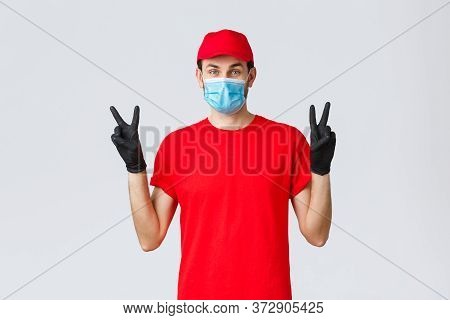 Covid-19, Self-quarantine, Online Shopping And Shipping Concept. Cute Delivery Guy In Red Uniform, F