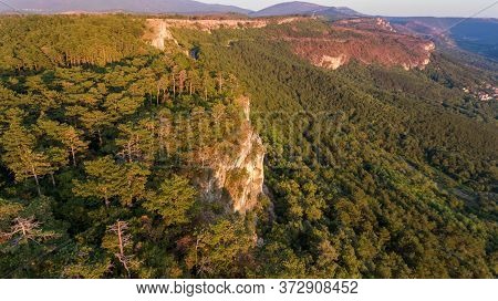 Aerial View Of Forest Gorwing Right To The Edge Of A Sheer Cliff.