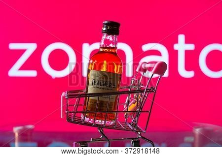A Bottle Of Whiskey In A Trolley In Front Of A Zomato Board