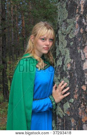 Dívka v zeleném pláštěnka, posazený na borovice