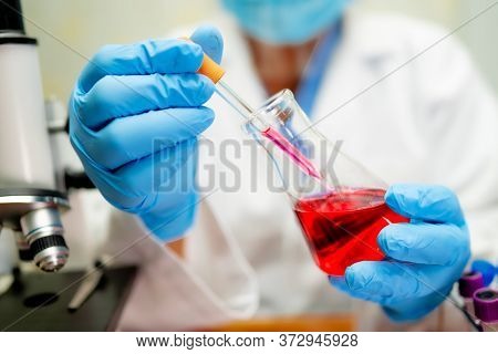 Scientist Holding Erlenmeyer Flask, Conical Flask Glassware With Red Color Liquid Solution In Scienc