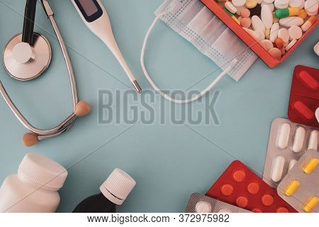 Colorful Tablets And Capsules In A Box, Thermometer, Statoscope, Medical Mask, Antiseptic Bottle, Co