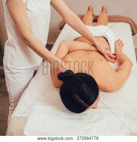 Top View Of Woman Lying On A Massage Table And Receive Back Massage, Spa Weekend. Antri-stress Massa