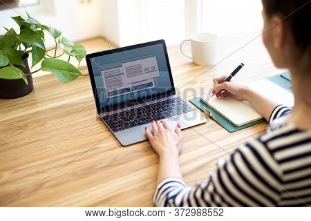 Cropped Shot Of Businesswoman Typing On Laptop's Keyboard And Makig Notes. Unrecognizable Woman Sitt