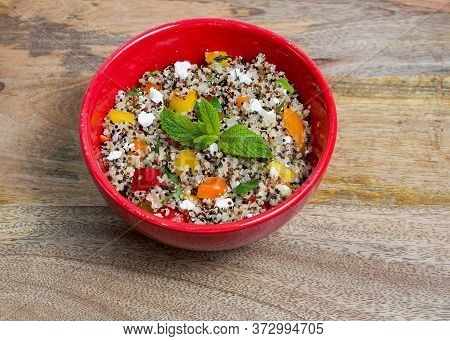 Closeup On Red Bowl With Tri-color Quinoa Salad On Wooden Background - Quinoa Is A Pseudograin That 