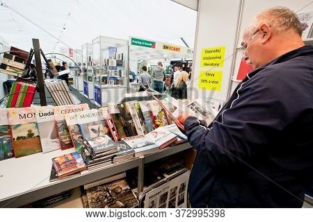Prague, Czechia: Customer Reading An Art Book Of The Publishing House Taschen In A Bookstore On May 