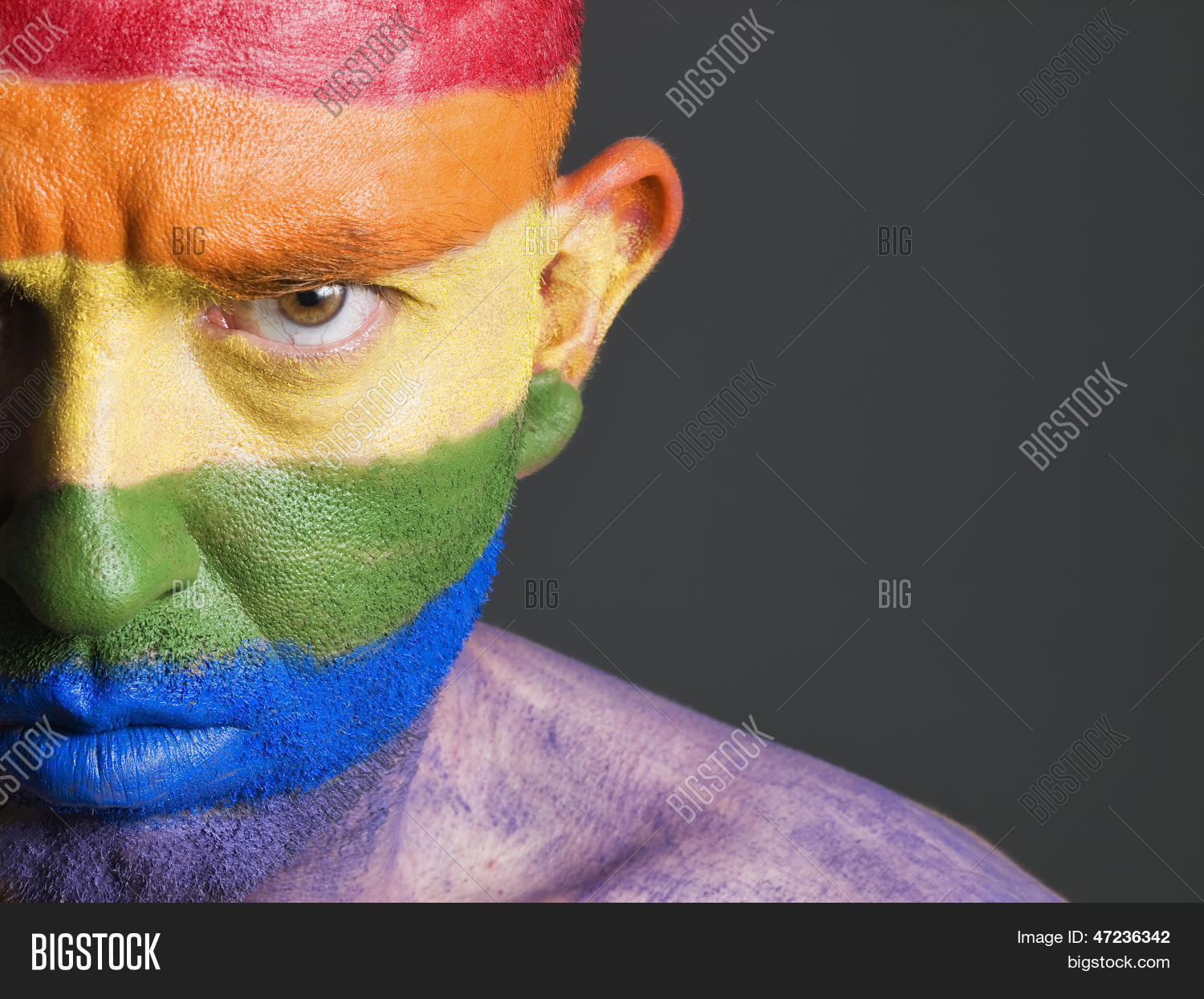 gay flag painted on the face of a man.