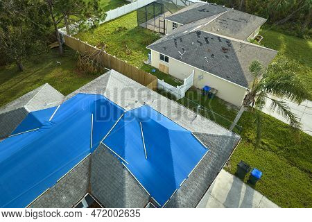 Top View Of Leaking House Roof Covered With Protective Tarp Sheets Against Rain Water Leaks Until Re