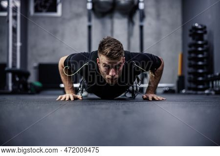 A Male Fitness Instructor In A Special Department For Ems Technology Does Push-ups And Arm Exercises