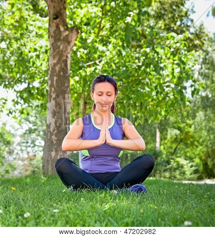 Smuk kvinde udøvelsen yoga i sommer park.
