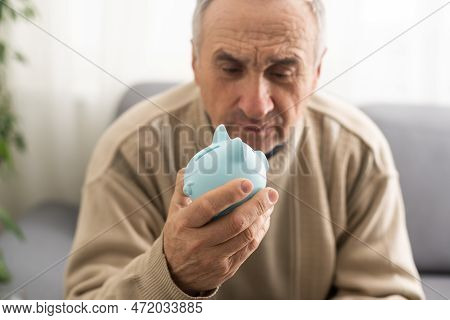 Senior Man Holding Piggy Bank. Financial Security Planning Concept. Economy And Saving.
