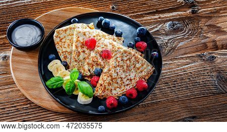 A Plate Of Pancakes With Cheese And Fruits