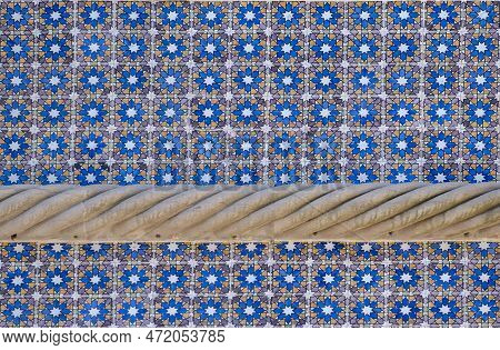 Detail Of Tiles Decorated With Geometric Shapes, And A Stone Ornament In The Form Of A Cord From The