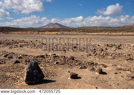 Stone Volcanic Desert And Mountains On A Horizon. Durch Park (parque Holandes). Blue Sky With White 
