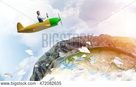 Happy Pilot Driving Small Propeller Plane On Background Of Blue Sky With Clouds. Traveling Around Th