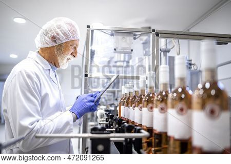 Experienced Supervisor Using Digital Tablet And Controlling Process Of Wine Production In Alcohol Be