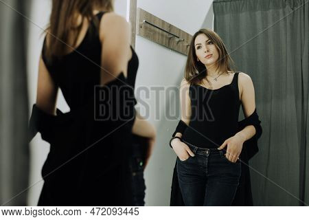 Woman With Dress In The Checkroom. A Clothing Store