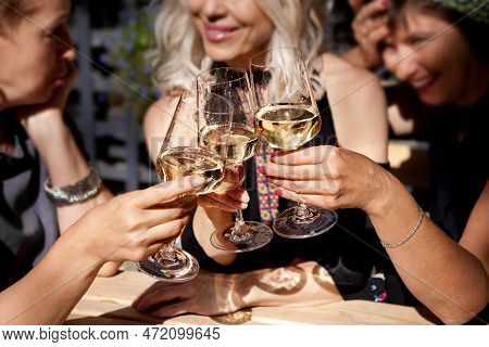 Women Clinking Glasses With Alcohol And Toasting, Party On Summer Terrace Cafe Or Restaurant, Celebr