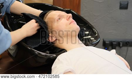 A Hairdresser Girl Wipes Her Hair With A Towel After Washing A Man With Limited Opportunities In A B