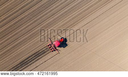 Above Top View, Of Tractor As Pulling Mechanical Seeder Machine Over Arable Field, Soil, Planting Ne