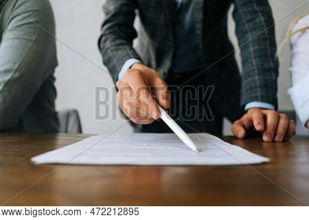 Close-up Hands Of Unrecognizable Businessman Pointing With Pen At Insurance Contract Showing Male Cl