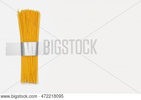 Long Raw Spaghetti Is Taped To A White Wall With Gray Duct Tape. Free Space For Text. Contemporary F